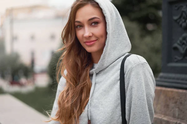 Smiling woman grey hoodie summer street day City life Modern happy urban female lose up portrait warm sportswear