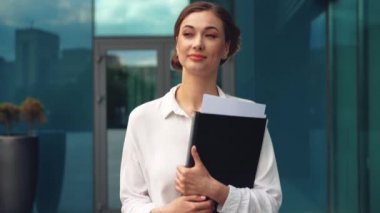 İş kadını başarılı kadın iş adamı dışarıda şirket binasının dış tarafında duruyor. Beyaz, kendine güvenen, profesyonel, iş kadını, orta yaşlı bir kadın. 