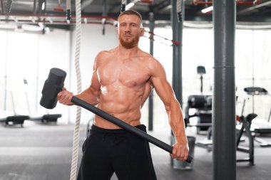 Erkek jimnastik çekici traktör tekerleğine çarptı. Büyük bir lastik sporcusuna çarptı. Orta yaşlı, yakışıklı vücut geliştirici, halterci. 