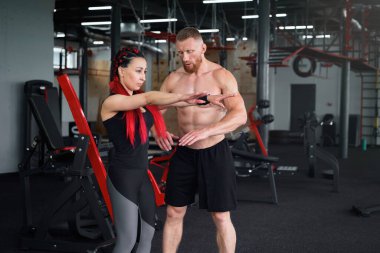 Kişisel antrenör antrenör antrenör antrenör sporcu erkek sporcu kadın jimnastik erkek sevgili birlikte antrenman yapan orta yaşlı yakışıklı sporcu insanlar kapalı alanda spor yapıyor. çömelme 