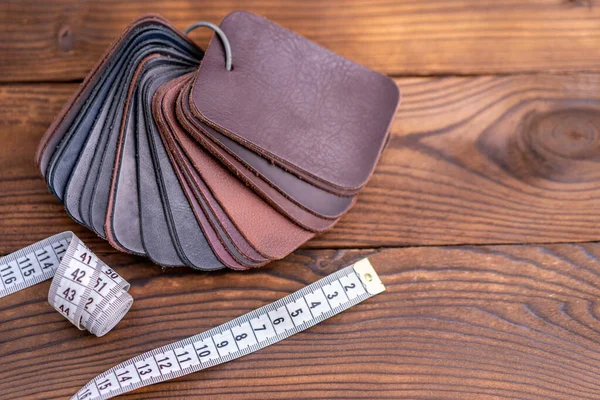 黒い木製のテーブルの上の靴や測定テープのための革サンプル デザイナー家具の服 — ストック写真