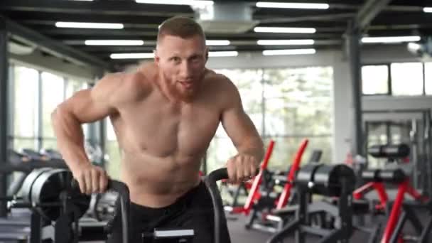 Man motionscykel gym cykling träning fitness. Fitness Man använder air bike cardio workout. — Stockvideo