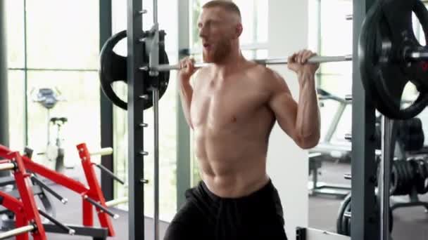 Ginásio homem barbell levantar pesos pratos máquina de exercício. Bonito atleta caucasiano treino — Vídeo de Stock