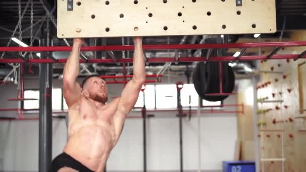 Homem escalada pegboard ginásio atleta treinamento braço força resistência alpinismo interior. Corpo ideal com abdominais perfeitos tronco nu — Vídeo de Stock