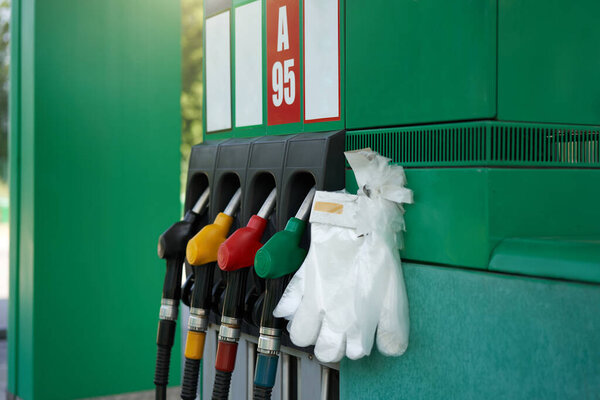 Coronavirus, covid-19 pandemic protective glove gas station gun. Epidemy protection. Personal protective equipment. self service Fuel station Stop virus.