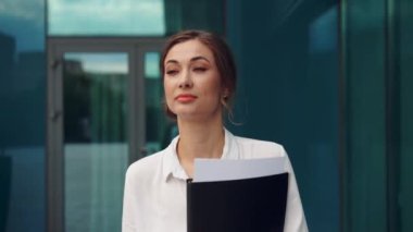 İş kadını başarılı kadın iş adamı dışarıda şirket binasının dış tarafında duruyor. Beyaz, kendine güvenen, profesyonel, iş kadını, orta yaşlı bir kadın. 