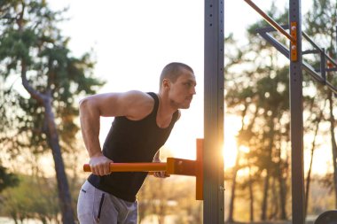 Yakışıklı beyaz erkekler sabah antrenman yapmak için havalanıyorlar. Kol pompalıyorlar. Spor sahası ormanı egzersizleri yapıyorlar. 
