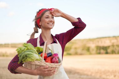 Woman farmer holding basket vegetable onion tomato salad cucumber standing farmland smiling Female agronomist specialist farming agribusiness Pretty girl dressed red checkered shirt and bandana clipart
