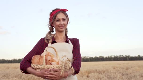 Female farmer standing wheat agricultural field Woman baker holding wicker basket bread product — Stock Video
