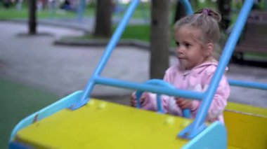 Salıncak çocuk oyun parkı küçük kız çocuk dışarıda oynuyor yaz güzel bir gün. Sevimli bir bebek halka açık parkta eğleniyor. 