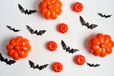 Cadılar Bayramı arka planı, turuncu dekoratif plastik balkabağı siyah kağıt yarasa beyaz karton Şükran Günü tebrik kartı deseni