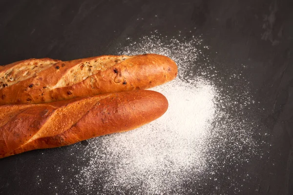 Deux Baguettes Françaises Croustillantes Reposent Fond Table Noir Foncé Graines — Photo