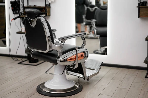 Classic vintage barber chair stands opposite mirror stylish white barber shop interior Man hairdresser salon Empty retro armchair in barbershop Professional hairstylist workplace Nobody Copy space