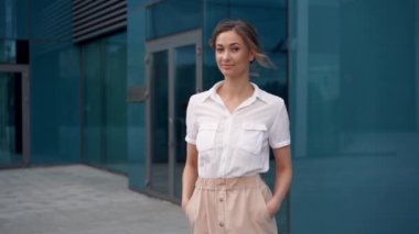 İş kadını başarılı kadın iş adamı dışarıda ağır çekimde şirket binasının dış tarafında duruyor. Gülümse mutlu Kafkas özgüveni profesyonel iş kadını orta yaşlı 