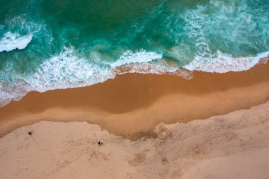 Kumlu sahilde dalgaların ezilmesinin en üst görüntüsü. Atlantik Okyanusu sahili hava manzarası