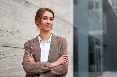İş kadını başarılı kadın iş adamı kollarını kavuşturdu şirket binasının dış tarafında gülümsedi mutlu Kafkas özgüveni profesyonel iş kadını orta yaşlı kadın girişimci