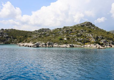 mavi sularda yat manzarası ve mavi gökyüzünde çeşitli dağ manzarası; yaz aylarında seyahat keyfi