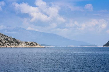 mavi sularda yat manzarası ve mavi gökyüzünde çeşitli dağ manzarası; yaz aylarında seyahat keyfi