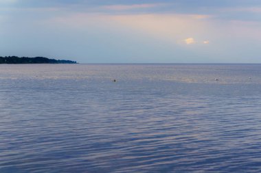 Gün batımından önce yaz akşamı, sakin sularda martılarla birlikte engin bir deniz.,
