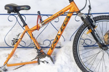 Tekerlekli turuncu bisiklet demir çit için bağlanmış