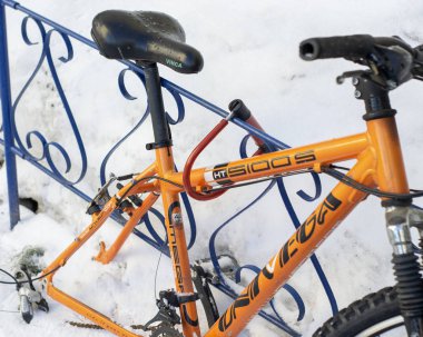 Tekerlekli turuncu bisiklet demir çit için bağlanmış