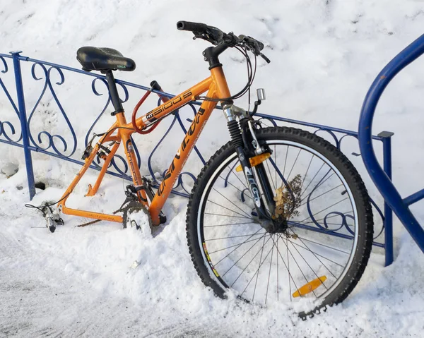 Tekerlekli turuncu bisiklet demir çit için bağlanmış
