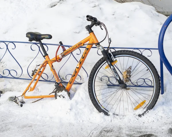 Wheelless narancssárga kerékpáros szíjazva a vas kerítés — Stock Fotó