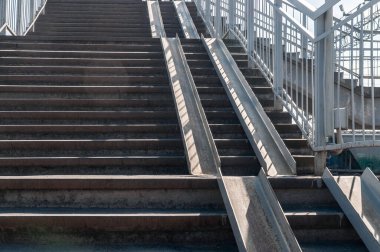 Tekerlekli sandalye için rahatsız edici rampası olan büyük dik merdivenler.