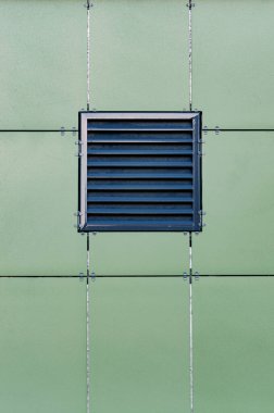 Modern bir binanın duvarının deseni. Havalandırmalı bir cephede. Yeşil seramik bileşik ön paneller. Havalandırma ızgaralı duvar