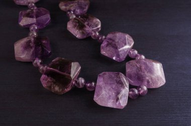 Ahşap zemin üzerinde ametist olan kolyeyi kapat.