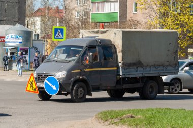 Petrozavodsk, Rusya - 11 Mayıs 2020, kavşakta yol işçilerinden oluşan küçük bir minibüs. Minibüsün tamponunda yol işaretleri var.