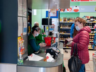 Petrozavodsk, Rusya - 2 Mayıs 2020 Coronavirus salgını sırasında tıbbi maskeli bir kasiyer ve alıcı