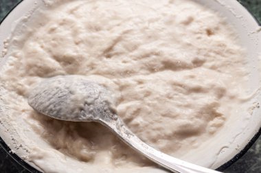 Pişirmeye hazır taze hamurlu metal kase.