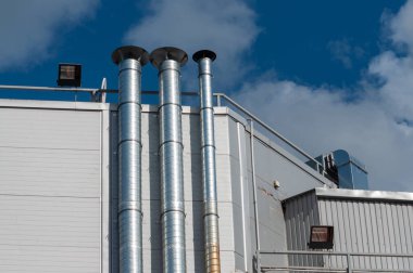 Bina duvarında üç gümüş metal başlık var. Dikey çerçeve