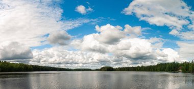 Güzel orman gölü ve üzerindeki beyaz bulutların panoramik görüntüsü.