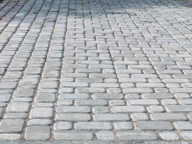 Kaldırım taşlarıyla döşenmiş bir yer. Döşeme taşları olan gri arkaplan
