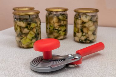 can sealing machine near jars with ready-made canned vegetables clipart