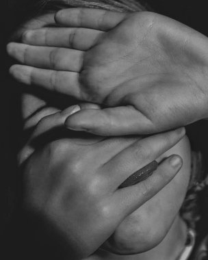 Kızın yüzü palmiyelerle kaplı siyah beyaz bir portre.