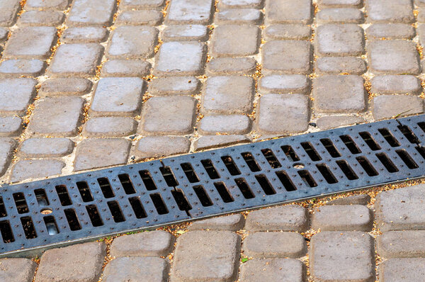 ливневая дренажная система на пешеходной дороге вымощена кирпичами