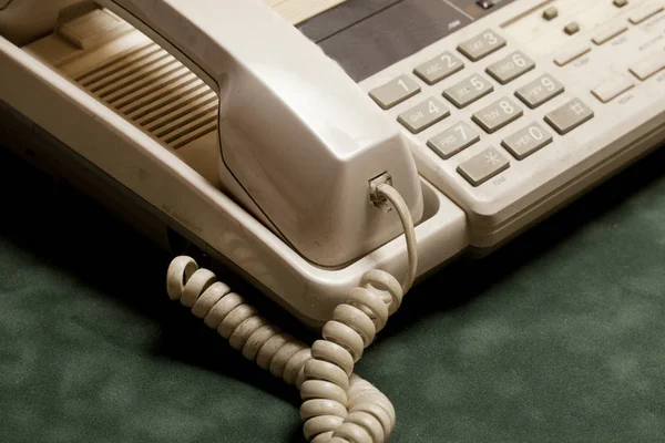 vintage phone with handset and answering machine on green velvet,the handset lies next