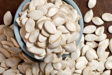 Kahverengi bir arka plan üzerinde mavi bir vazo büyük kabak çekirdeği