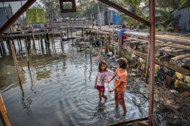 Sihanoukville, Kamboçya. 26 Şubat 2019 : Sihanoukville'de ahşap evlerinin inşa edildiği deniz kenarında oynayan köy çocukları 