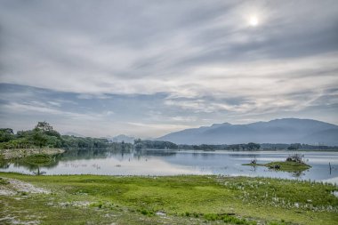 Bulutlu gökyüzü altında yeşillik ile tin cevheri gölü Manzara görünümü 