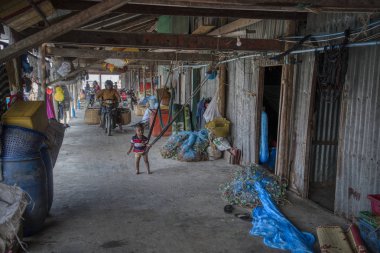 Sihanoukville, Kamboçya. 26 Şubat 2019: Sihanoukville Balıkçı Köyü'ndeki ahşap evinin önünde balıkçıağı tamir eden balıkçının sahnesi. 