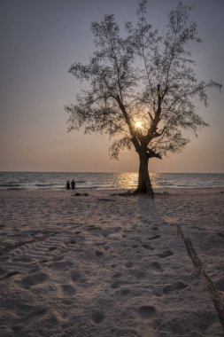 Sihanoukville, Kamboçya - 26 Şubat 2019: Ziyaretçiler Otres Plajı'nda sahilde gezinirken güzel gün batımı altın saat sahnesi