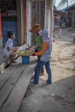 Sihanoukville, Kamboçya. 25 Şubat 2019 : Sihanoukville balıkçı Köyü balıkçı evinde bulunan müşteriye yiyecek satan bayan tüccarın sahnesi.