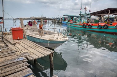 Sihanoukville, Kamboçya,. 26 Şubat 2019: Ticari sürat teknelerinin Tomnub Rolork Yolu boyunca diğer plajlarda insanları aldığı ahşap iskele veya iskelenin yakınındaki tekne parkının sahnesi. 