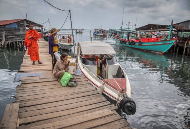 Sihanoukville, Kamboçya,. 26 Şubat 2019: Ticari sürat teknelerinin Tomnub Rolork Yolu boyunca diğer plajlarda insanları aldığı ahşap iskele veya iskelede bekleyen insanların sahnesi. 
