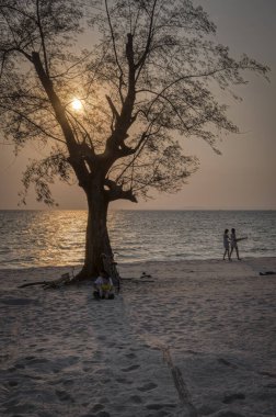 Sihanoukville, Kamboçya - 26 Şubat 2019: Ziyaretçiler Otres Plajı'nda sahilde gezinirken güzel gün batımı altın saat sahnesi