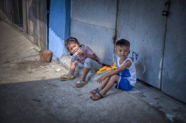 Sihanoukville, Kamboçya - 25 Şubat 2019: Sihanoukville balıkçı Köyü'ndeki evlerinin koridorunda oynayan kardeş ve erkek kardeş sahnesi